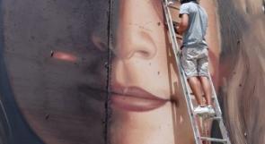 رسام إيطالي ينجز لوحة للأسيرة عهد التميمي على جدار الفاصل في بيت لحم