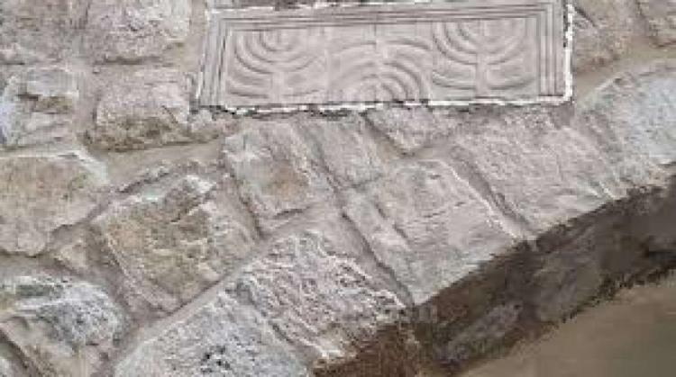 مستوطنون يثبتون حجرا يحمل كتابات عبرية في بالخليل