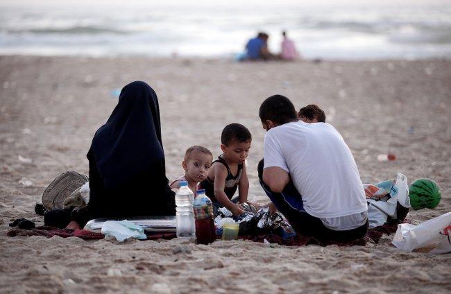 عائلة فلسطينية تتناول الافطار على شاطئ بحر غزة