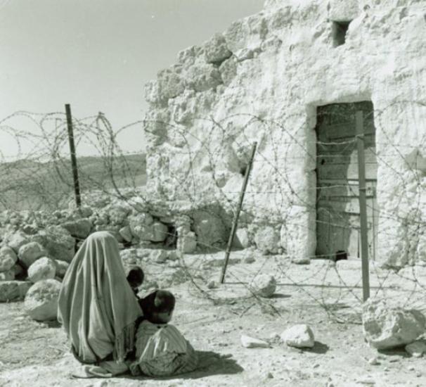 فلسطينية لاجئة تقف بعيدة عن بيتها خلف "الخط الأخضر" وهو خط الهدنة الذي تم التوصل إليه في أعقاب الحرب العربية-الإسرائيلية عام 1948