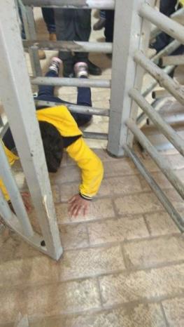 طفل يجد طريقه بين اذرع آلة التحكم في حركة العابرين على حواجز الاحتلال