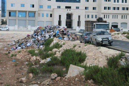 جرافات الاحتلال تلقي النفايات في أحياء بالبيرة