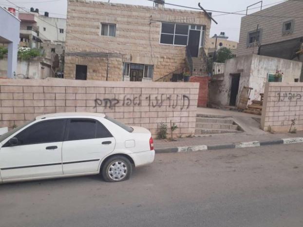 مستوطنون يعطبون مركبات ويدمرون مزروعات ويخطون شعارات عنصرية في دير عمار