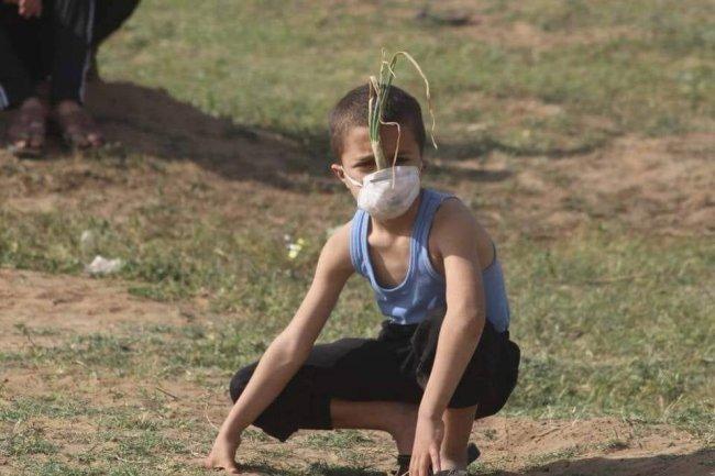 ببصلة وكمامة طفل يوم الأرض يواجه غاز الاحتلال على حدود غزة